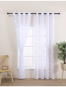 Close-up of white lace sheer curtain with vintage floral pattern and metal grommets