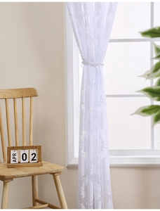 Close-up of white floral lace curtain with luxury pearl tieback in a bedroom