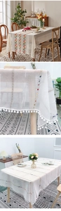 Detail of embroidered polyester tablecloth with colorful dots and cream pom-pom fringes