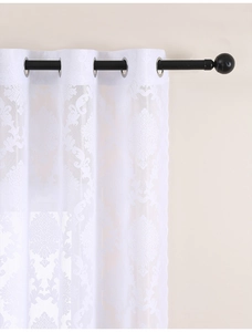 Detail of white lace curtain with damascus floral pattern and silver metal eyelets