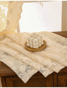 Close-up of beige crochet lace curtain with vintage floral patterns and scalloped edges