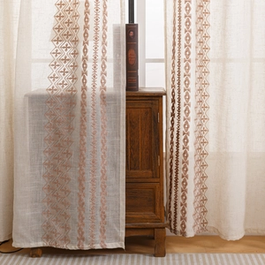 Beige linnen gordijnen met bruin etnisch borduursel en geometrische patronen in interieur