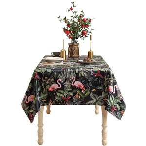 Tropical rainforest tablecloth featuring pink flamingos and green leaves on black background
