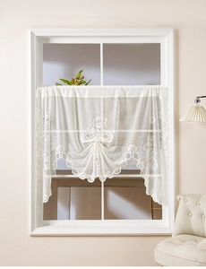 Close-up of beige lace cafe curtain with delicate floral embroidery and elegant tie design