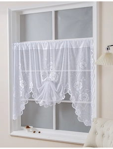 Detail of white lace cafe curtain with floral embroidery and scalloped lace edges