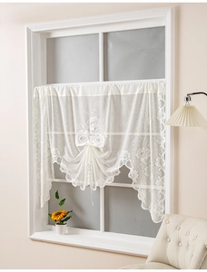 Detail of floral embroidery on beige lace cafe curtain with elegant scalloped edges