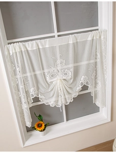 Detail of floral lace cafe curtain with adjustable drawstring and scalloped edges