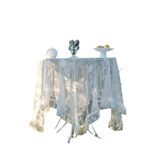Elegant white lace tablecloth with hollow embroidery and ruffled edges for a round table