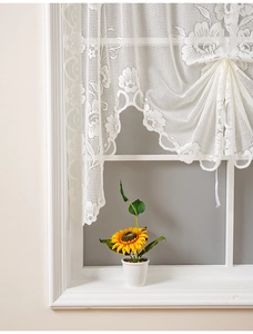 Detail of beige lace cafe curtain featuring floral embroidery and adjustable drawstrings