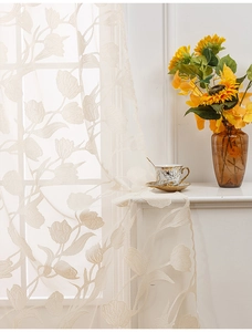 Detail of beige lace door curtain featuring elegant tulip floral embroidery and texture