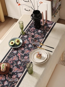 Detailed texture of black table runner with floral paisley pattern on linen fabric