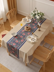 Macro detail of blue floral table runner with red peony patterns and geometric borders