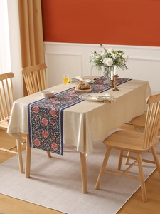 Detail of dark blue floral table runner with red lotus patterns on a beige tablecloth