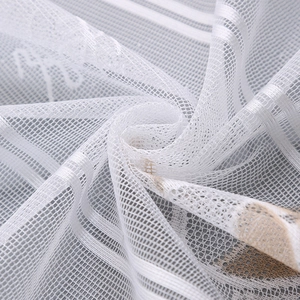 Macro detail of white mesh lace fabric featuring satin stripes and floral embroidery