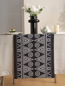 Detail of waterproof table runner with black geometric patterns on coarse fabric texture