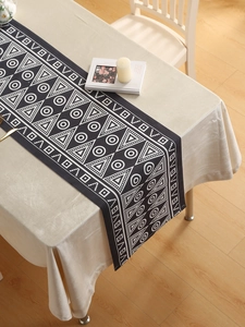 Detail view of modern black geometric table runner with waterproof fabric and tassel fringe