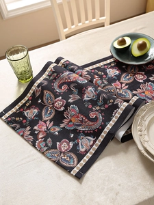 Detail of bohemian paisley floral table runner with waterproof dark base and white border