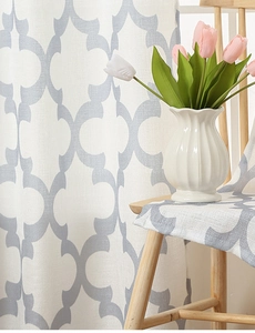 Detail of American style white linen curtains with grey geometric pattern in a cozy room