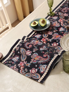 Close-up of bohemian paisley floral table runner on dining table with avocado plate