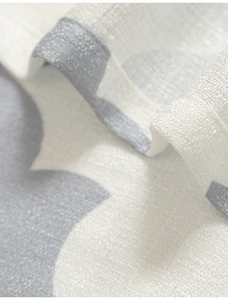 Detail of white linen curtain with gray gourd flower print and neat hem stitching