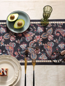 Detailed top view of a dark blue paisley table runner with high-quality floral fabric texture