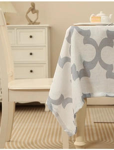 Close-up of thick polyester tablecloth with gray clover patterns on beige fabric