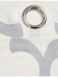 Detail of white textured fabric curtain with grey geometric patterns and silver metal grommet