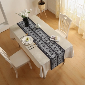 Modern black geometric table runner with white triangle patterns on a dining table