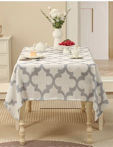 Detail of grey clover pattern on thick beige polyester tablecloth for dining room decor