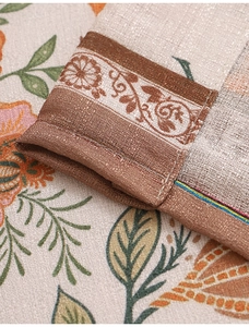 Close-up of floral linen fabric curtains showing detailed stitching and vintage texture
