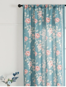 Close-up of blue floral curtain with rose print and white decorative lace border