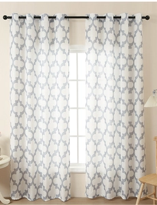 Detail of white Moroccan geometric pattern curtains with silver grommets and linen texture