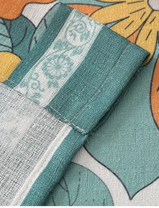 Close-up of floral plant pattern with neat double stitching and linen texture detail