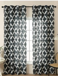 Detail of black and white Moroccan trellis curtains with metal grommets on a rod