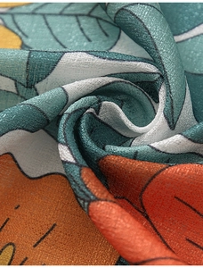 Detail of linen-textured curtain fabric with blue leaves and orange floral pattern