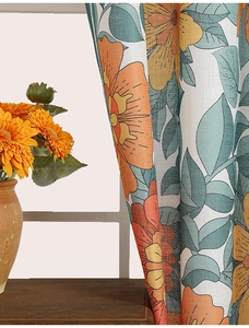 Close-up of modern botanical curtain fabric with orange flowers and green leaves