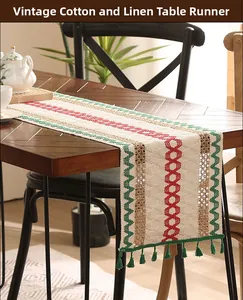 Close-up of vintage cotton linen table runner with geometric prints and green fringe tassels