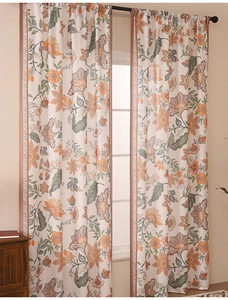 Detail of botanical print curtain with orange and green leaves and geometric lace edge