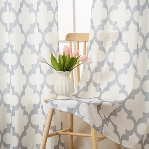 Modern white curtains with grey trellis patterns on a wooden chair with tulips