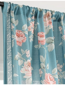 Close-up of blue floral curtain with pink peonies and decorative vintage border lace