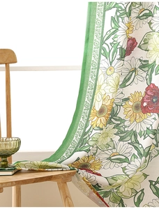 Detail of floral print curtains with sunflowers and daisies on textured white fabric
