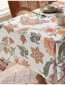 Detail of floral linen tablecloth showing elegant drape and orange flower pattern