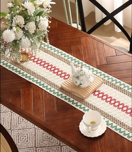Detail of bohemian striped table runner with colorful zigzag patterns on dark wood