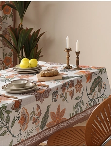 Macro shot of a floral linen tablecloth with orange flowers and vintage rustic texture