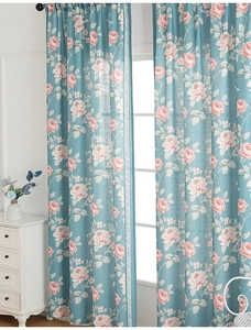 Detailed close-up of floral curtains featuring blue-green fabric with pink rose patterns