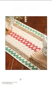 Detail of bohemian woven table runner with red and green geometric embroidery on linen fabric