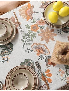 Detail of floral print linen tablecloth with vintage orange and purple flower patterns