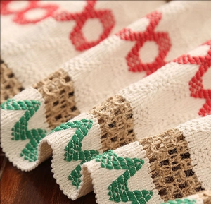 Close-up of rustic textured jacquard table runner with red and green Christmas weave