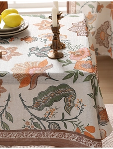 Detail of floral linen tablecloth with orange flowers and vintage leaf patterns
