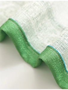 Detailed macro shot of linen texture fabric with light green trim on modern curtains